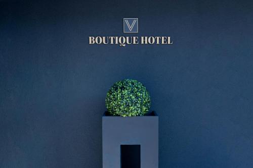a green plant in a white pot in front of a wall at V Boutique Hotel Böblingen in Böblingen