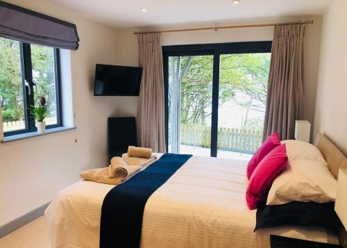 1 dormitorio con cama y ventana grande en Sea Cliff View Designer Home, en Lyme Regis