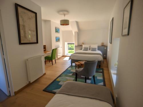 Habitación con 2 camas, mesa y sillas en Le Clos du Val, en Quibou