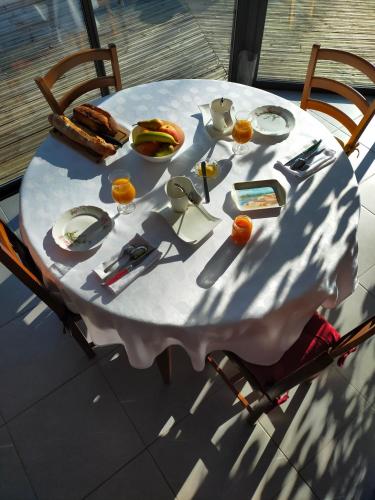 - une table blanche avec de la nourriture et des ustensiles dans l'établissement HOLLY WOOD, à Ault