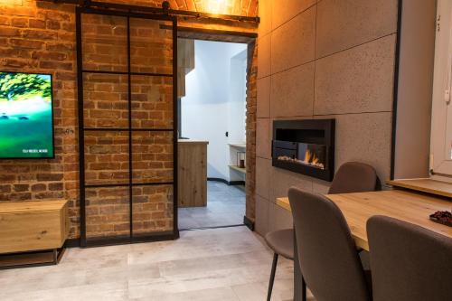 a dining room with a fireplace and a television at Apartament Black Loft in Nysa