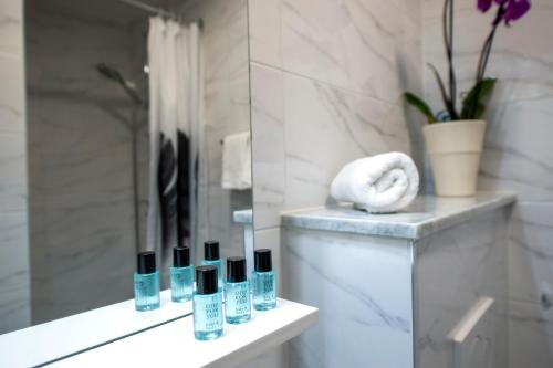 een badkamer met een aanrecht met diverse flessen cosmetica bij Casa Caterina in Rovinj