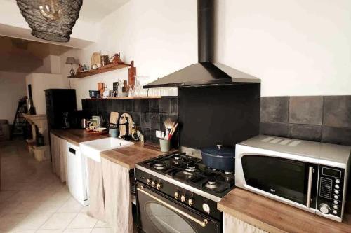 Il comprend une cuisine équipée d'une cuisinière et d'un four micro-ondes. dans l'établissement Jolie maison avec terrasse proche centre et gare, à Rochefort