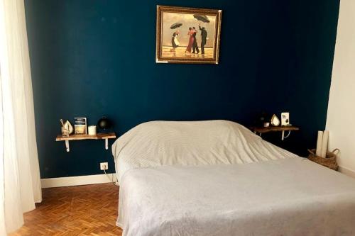 - une chambre avec un mur bleu et un lit dans l'établissement Jolie maison avec terrasse proche centre et gare, à Rochefort