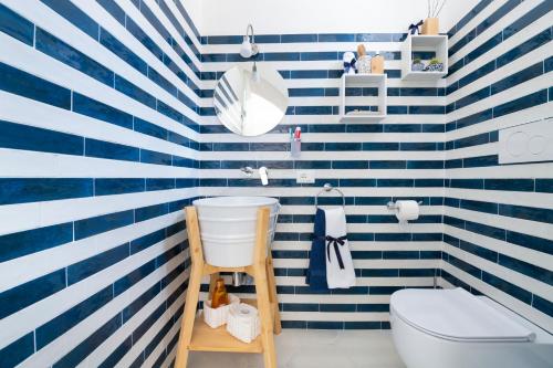 baño con pared de rayas azules y blancas en Appartamento luminoso e romantico ANyMA, en Massa Lubrense