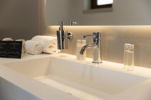 a bathroom sink with a faucet and a mirror at Hotel Monte Sarago in Ostuni