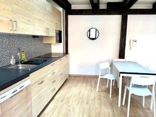 - une cuisine avec des placards en bois, une table et des chaises dans l'établissement Michalska Residence 3, à Bratislava