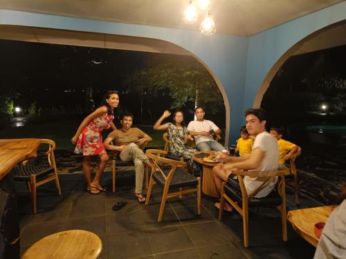 a group of people sitting around a table at La Collina Villa in Jepara