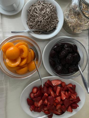 una mesa con platos de frutas y cuencos de frutas secas en Hotel De Rosa, en Maiori