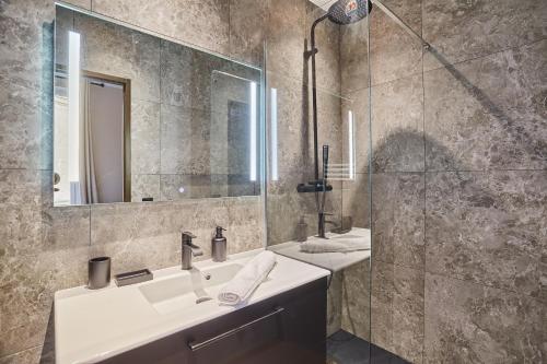 une salle de bain avec un lavabo, un miroir et une douche dans l'établissement Apartment Concorde Madeleine by Studio prestige, à Paris