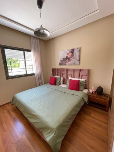 a bedroom with a large bed with two pink pillows at Chic & cosy Flat Near Airport lockbox fast wifi in Nouaceur