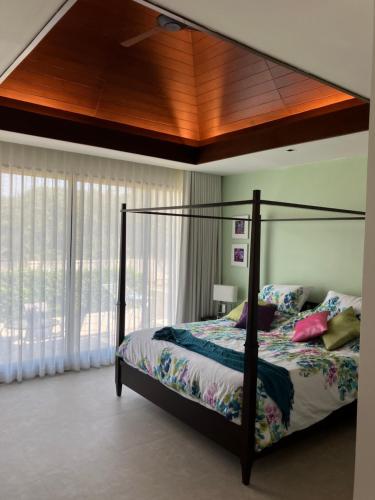Kluai Mai Luxury Pool Villa, Panorama Resort في هوا هين: غرفة نوم مع سرير مظلة ونافذة