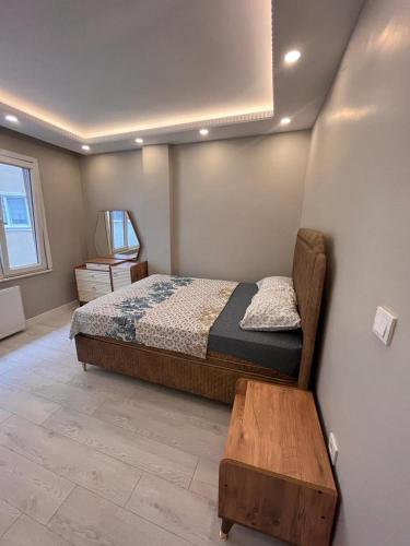 een slaapkamer met een bed en een houten tafel bij SÜPER KONUMDA LUX,ŞÖMİNELİ TASARIM DAİRE in Istanbul