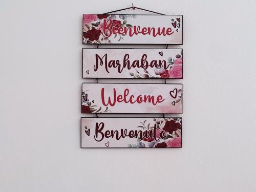 a group of signs with flowers on a wall at villa mimosa avec parking intérieur in Tataouine