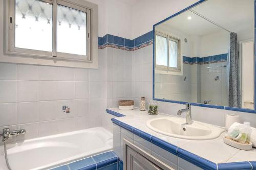 une salle de bain avec une baignoire, un lavabo et un miroir dans l'établissement Charmant Appartement à 300 mètres des plages de la Croisette, à Cannes