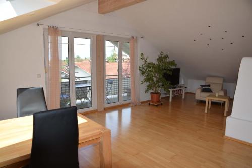 een woonkamer met een eettafel en een balkon bij Ferienwohnung Dorfblick in Chieming