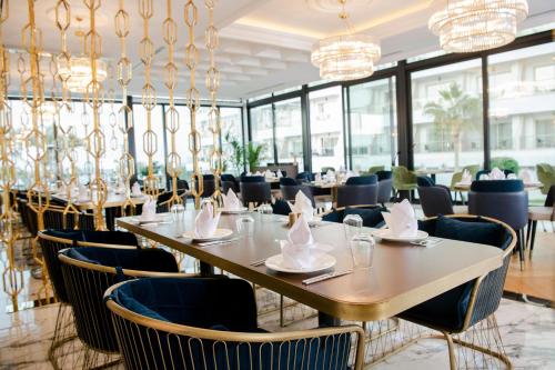 a dining room with tables and chairs and chandeliers at Acapulco Resort Hotel in Kérynia