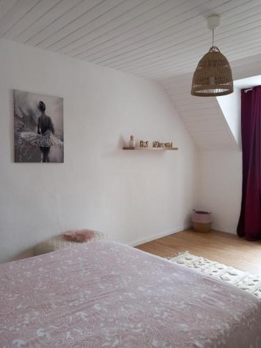 une chambre avec un lit et un tableau au mur dans l'établissement Maison 3 étoiles proche des plages, à Pont-lʼAbbé