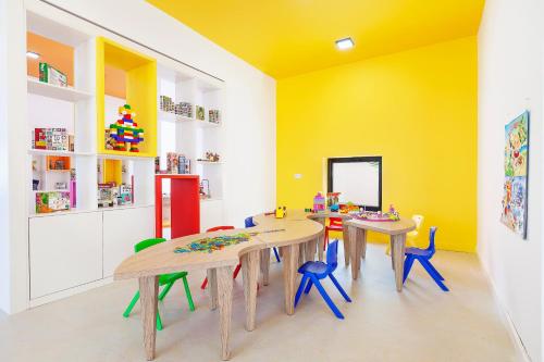 a room with two tables and chairs and a yellow wall at Acapulco Resort Hotel in Kérynia