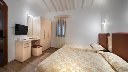 a hotel room with two beds and a television at Acapulco Resort Hotel in Kérynia