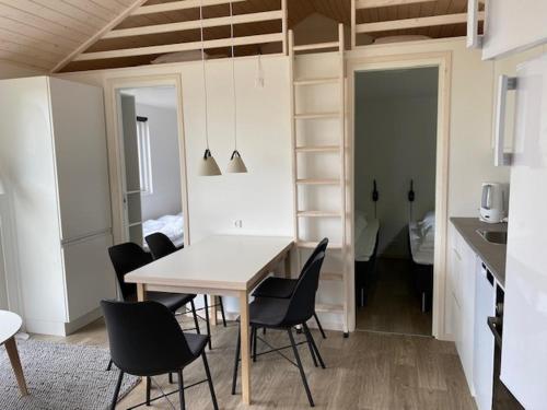 een eetkamer met een tafel en stoelen en een slaapkamer bij Rosenvold Strand Camping in Stouby