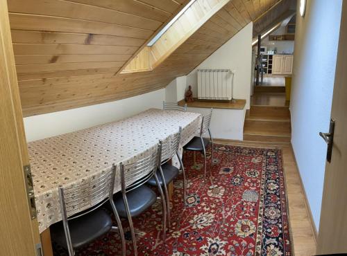 a dining room with a table and chairs on a rug at Privatsalatin 