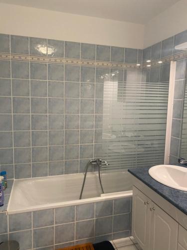een badkamer met een bad en een wastafel bij Bel appartement proche Monaco in Beausoleil