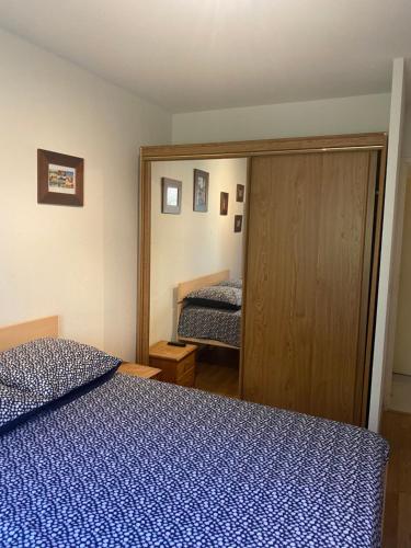 una camera con letto blu e specchio di Bel appartement proche Monaco a Beausoleil