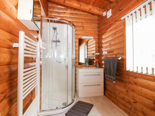 y baño con ducha y paredes de madera. en Rocksite, en Blairgowrie
