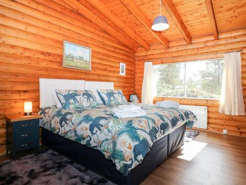 a bedroom with a bed in a log cabin at Rocksite in Blairgowrie