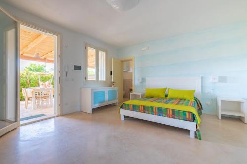 a bedroom with a bed and a table and a window at Cava Li Santi Residence in Santa Caterina di Nardò