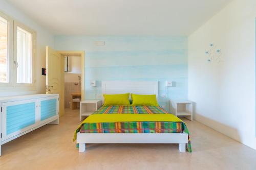 a bedroom with a bed with a colorful blanket at Cava Li Santi Residence in Santa Caterina di Nardò