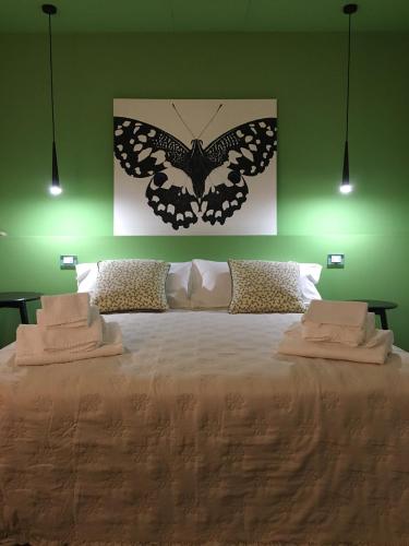a bedroom with a large bed with a butterfly painting on the wall at Casa Vacanza Fontanelle in Iseo