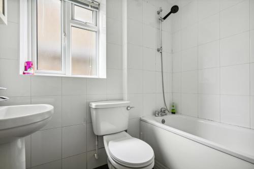 uma casa de banho branca com um WC e um lavatório em Cozy Wimbledon Apartment em Londres