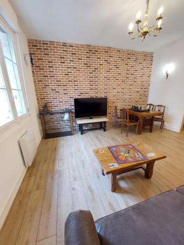 - un salon avec un mur en briques et une table dans l'établissement La Chambre des Sorciers, à Blois