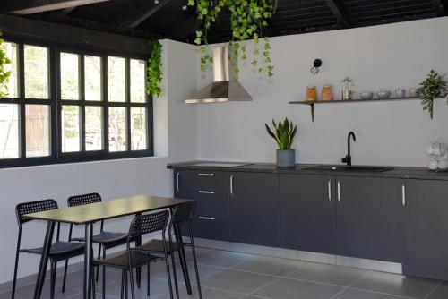 a kitchen with black cabinets and a table and chairs at Casa Doris in Sovata