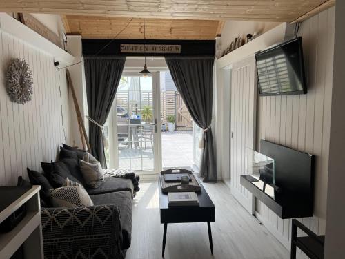 a living room with a couch and a tv at Beautiful 1-Bed Cabin in Hayling Island in South Hayling