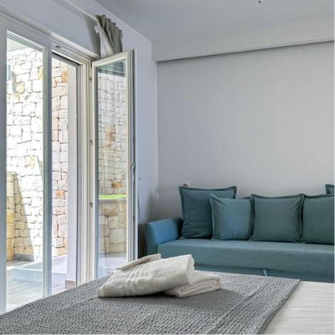 sala de estar con sofá azul y ventana en SUITE CALA PAURA en Polignano a Mare