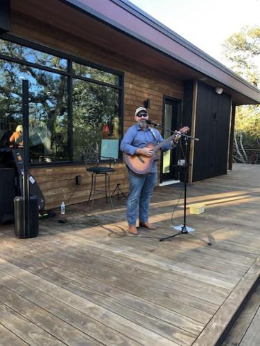 a man standing on a deck playing a guitar at 12 Fires Luxury Glamping #5 in Johnson City