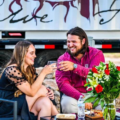 a man and woman sitting at a table drinking wine at 12 Fires Luxury Glamping #5 in Johnson City