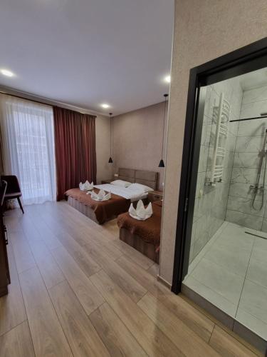 a hotel room with two beds and a shower at Hotel Sweet Night in Stepantsminda