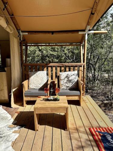 a porch with two chairs and a table on a deck at 12 Fires Luxury Glamping #5 in Johnson City