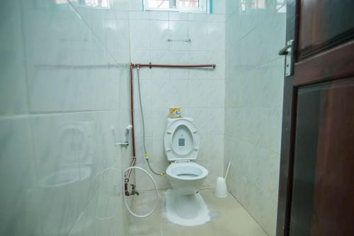 a bathroom with a toilet and a shower at Kaanasisi 3 Bedrooms Apartment in Dar es Salaam