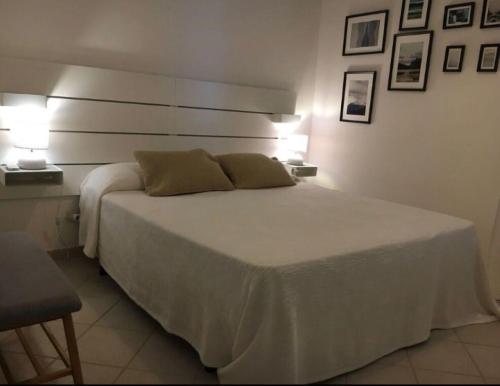 a bedroom with a large white bed with two lamps at Villa sul Mare in Siracusa