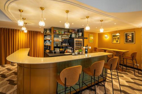 a bar in a restaurant with bar stools at Le Splendid Hotel Lac D'Annecy - Handwritten Collection in Annecy