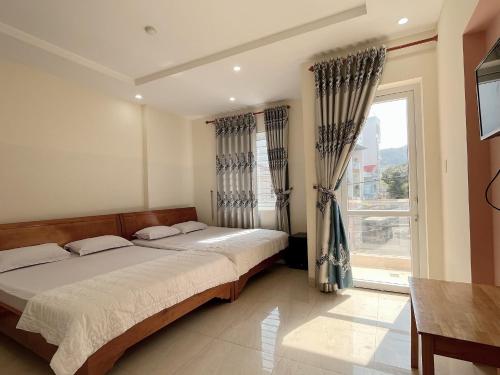 a bedroom with a bed and a large window at Motel Phương Thảo Phong Tập Thể in Vung Tau