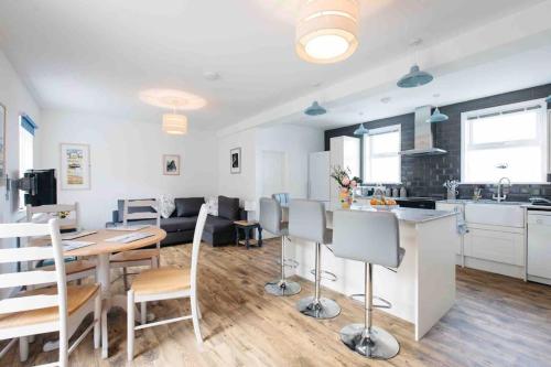 a kitchen and living room with a table and chairs at Spacious flat St Ives former farmhouse, parking in St Ives