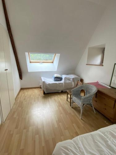une chambre mansardée avec deux lits et une fenêtre dans l'établissement Spacious Longere,heated swimming pool, idyllic setting, Southern Brittany, FR, à Pluherlin