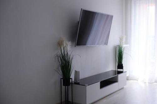 a living room with a tv on a white wall at D&A Apartments Obozowa in Warsaw