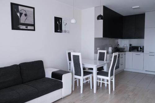 een woonkamer met een bank en een tafel en stoelen bij D&A Apartments Obozowa in Warschau